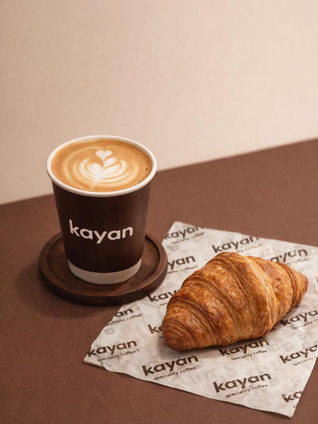 Kayan Coffee — a latte with latte art next to a golden croissant